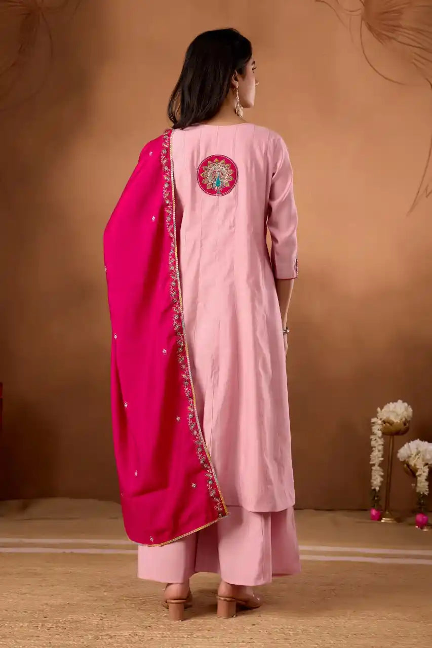 Woman wearing a pink traditional outfit with a pink dupatta against a brown background